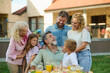 © Zamrznuti tonovi - Happy family enjoying outdoor lunch together in backyard