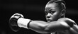 © BerkahStock - Determined female boxer throws a punch in black and white.
