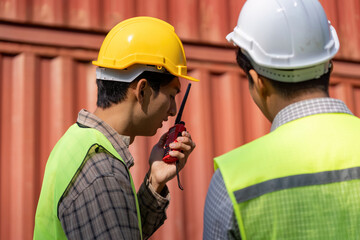 Construction engineers discussing logistics and plans on-site with communication devices.