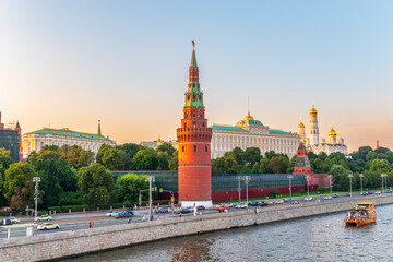 Wall Mural - View of Kremlin with Vodovzvodnaya tower, Grand Kremlin Palace from repaired Bolshoy Kamenny Bridge in Moscow city on sunny summer day. Cruise ship sails on the Moscow river