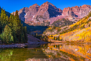 Wall Mural - Maroon Bells, Colorado with reflection of the mountains in the mountain lake with yellow aspen trees in the autumn on a sunny autumn day