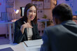 © Phimwilai - Asian businesswoman is explaining a new strategy to a businessman sitting in front of her at the office desk at night, using a pen to emphasize her concepts