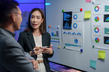 Sticker - Business professionals engage in a data analysis discussion in a modern office setting. Charts and graphs on a whiteboard illustrate key performance metrics and trends