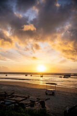 Wall Mural - serene beach sunset with boats and dramatic clouds.