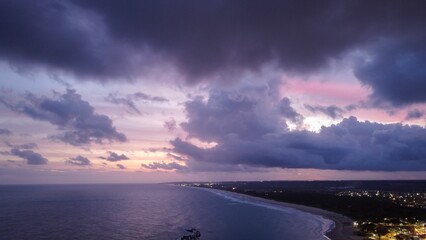 Wall Mural - coastal sunset with vibrant clouds and serene ocean.