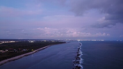 Wall Mural - coastline at dusk with city lights and purple sky.