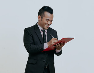 Wall Mural - Asian boss manager businessman smiling confident while writing a list, isolated over white background.