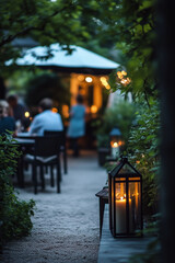 Wall Mural - Small garden terrace with garden furniture and lanterns and blurred people on background on warm summer evening.