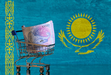 Wall Mural - A 10,000 Kazakh tenge banknote in a miniature shopping cart in a photo of the Republic of Kazakhstan flag