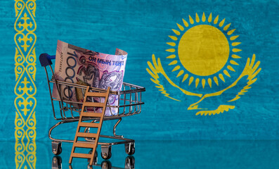 Wall Mural - A 10,000 Kazakh tenge banknote in a miniature shopping cart in a photo of the Republic of Kazakhstan flag