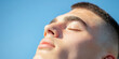 © Lila Patel - Close-up of a Young Man's Face Against a Blue Sky