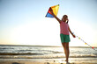 © New Africa - Cute little child playing with kite on beach near sea at sunset. Spending time in nature