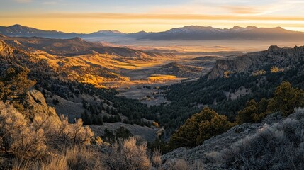 Wall Mural - Majestic sunset over a valley with golden hills, mountains, and evergreen forests.