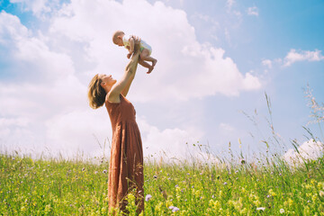 Wall Mural - Mother and baby. Concept of natural maternity and motherhood. Beautiful woman and little baby happy together in green nature background. Loving mom with child outdoors.