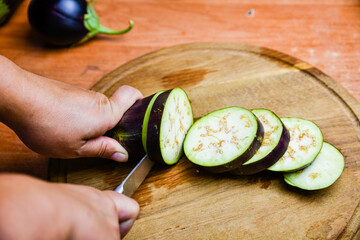 Wall Mural - Woman cutting eggplant on the cutting board