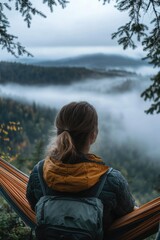 Wall Mural - A person relaxing in a hammock, surrounded by fog and greenery