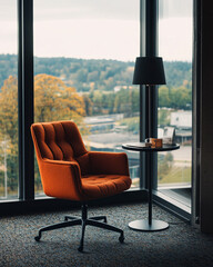 Wall Mural - Orange armchair and lamp by a large window, overlooking trees and buildings on a cloudy day.