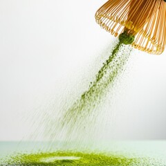 Matcha tea powder falling from bamboo whisk on light green surface