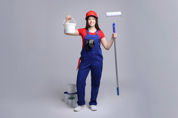 Wall Mural - Professional painter with roller and buckets of paint on light grey background