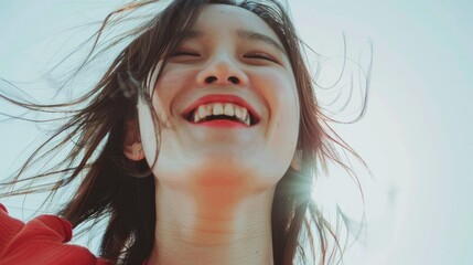 Wall Mural - Joyful young woman with flowing hair smiling brightly against a sunlit background, capturing a moment of happiness