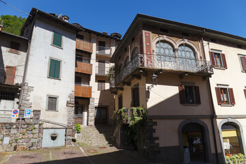 Wall Mural - GROMO, ITALY - MAY 22, 2024: Street view of historical village with narrow cobbled streets, shot in bright summer light