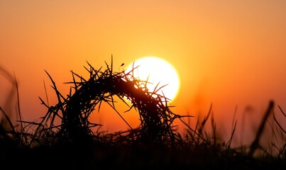 Wall Mural - Silhouette of a crown of thorns with the sun setting in the background, symbolizing the suffering and heroism during Jesus' passion story for the Easter celebration.