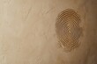 © MrHamster - Impressed fingerprint design on a textured tan colored surface