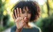 © Sergey - Close up of African American woman showing stop gesture with hand blurred background, young female protesting against domestic violence and abuse, bullying, saying no to gender discrimination