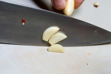 Wall Mural - cutting garlic with a knife