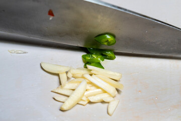 Wall Mural - cutting chili pepper with a knife on the cutting board