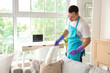 © Pixel-Shot - Male janitor cleaning sofa cushion with pp-duster in room