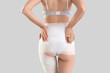 © Pixel-Shot - Young woman in anti-cellulite bandage on light background, back view. Body wrap procedure