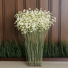 Canvas Print - Baby's breath flower arrangement decorates interior; greenery behind, on wood wall. For home decor site