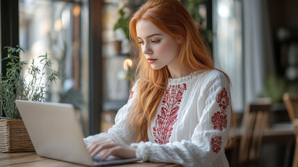 Wall Mural - Golden hair business woman in white dress with embroidery working with a laptop