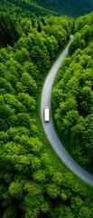 Poster - Van drives winding road through a lush forest; mountains blur in the background. Travel website use