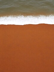 Wall Mural - Waves washing up onto a brown sandy shore. Ocean in the background. Possible banner or background use