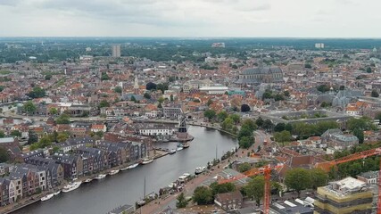 Wall Mural - Dolly zoom. Haarlem, Netherlands. Windmill De Adriaan (1779). Windmill from the 18th century. Panoramic view of Haarlem city center. Cloudy weather during the day. Summer, Aerial View