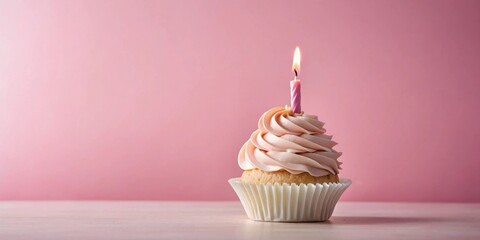 Wall Mural - A single cupcake with pink frosting and a lit candle on a pink background.