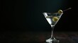 © Александр Бердюгин - An elegant clear martini with a green olive garnish, set on a black surface, evoking refined cocktail allure and upscale bar ambiance.