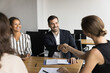 © fizkes - Male boss shaking hands female employee as acknowledging sign of job well done, welcoming new staff member, showing mutual respect after productive negotiation, discussion or meeting. Deal, business