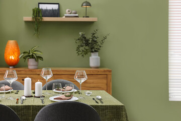 Aufkleber - Stylish table setting with olive tablecloth, glasses and candles in dining room