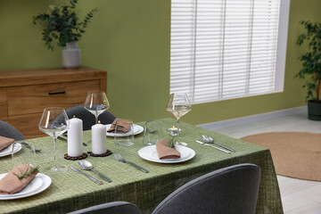 Aufkleber - Stylish table setting with olive tablecloth, glasses and candles in dining room