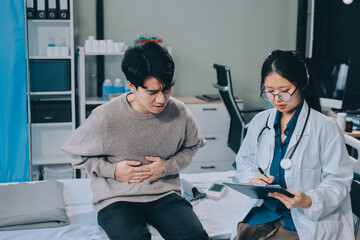 Wall Mural - Female physician reads medical history while visiting her patient