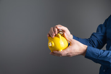 Canvas Print - Caucasian businessman showing piggy bank and coin.