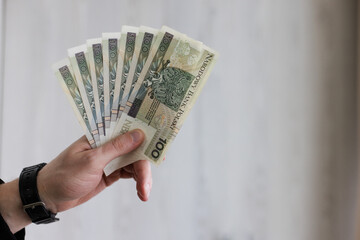 Man holding a fan from 100 bills banknotes of Polish zloty. 