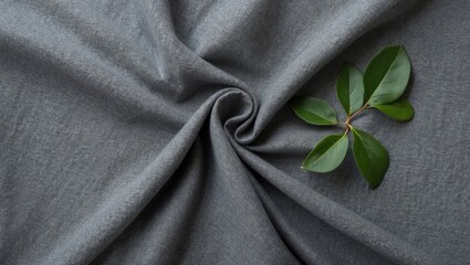 Leinwandbilder - Elegant grey fabric background with soft texture and green foliage accent for design and textile applications.