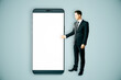 © Who is Danny - Businessman presenting a giant smartphone with blank white screen.
