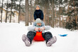 © Ljustina - Children having fun sliding down on snow in winter forest