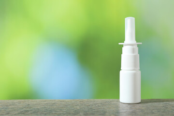 Wall Mural - Allergy treatment. Nasal spray on wooden table against blurred background. Space for text