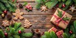 © sasiprapa - A Festive Christmas Composition Featuring Gingerbread Cookies, Pine Branches, Gifts, and Ornaments on a Rustic Wooden Surface
